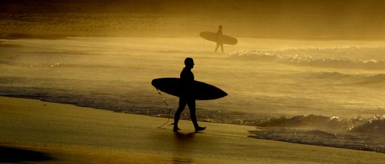 SURFERS WALK ALONG SYDNEY'S FAMOUS BONDI BEACH