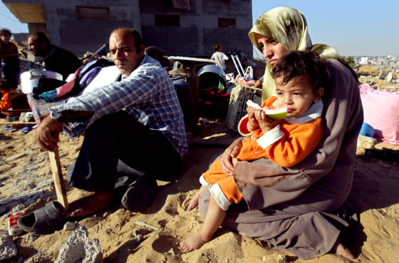 PALESTINIAN FAMILY SITS ON RUBBLE OF DEMOLISHED HOUSE AFTER ISRAELI TROOPS PULLED OUT RAFAH CAMP
