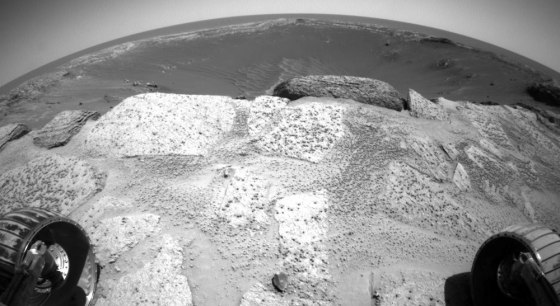 This wide-angle view from a hazard avoidance camera on NASA's Opportunity rover shows slabs of rock strewn with "Martian blueberries" in the foreground, with the stadium-sized Endurance Crater stretching out beyond the brink.