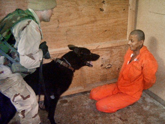 In this undated still photo, an Iraqi detainee appears to be intimidated by a U.S. soldier using a trained dog inside the Abu Ghraib prison, west of Baghdad.