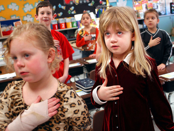 Jessica Dierkes, left, and Amanda Gehring — first grade students at Longstreth Elementary School — pledge allegiance to the flag March 24 in Warminster, Pa. 