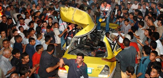 Medics and residents surround the wreckage of a car after it was hit by an Israeli army missile at the Balata refugee camp, adjacent to the West Bank town of Nablus, on Monday.