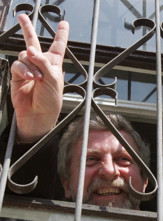 Opposition leader Milinkevich flashes victory sign from court room in Minsk