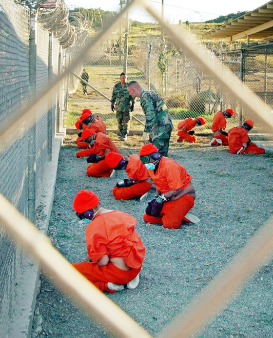 Alleged Taliban and al-Qaida detainees sit in a holding area at Camp X-Ray at Guantanamo Bay, Cuba, during in-processing to the temporary detention facility in this Jan. 11, 2002 file photo. 