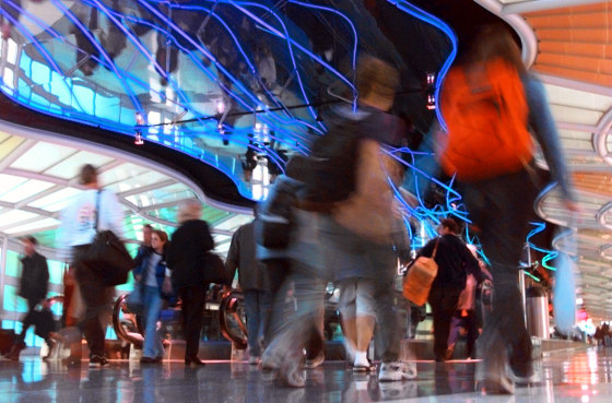 TRAVELERS HUSTLE THROUGH UNITED AIRLINES TERMINAL AT O'HARE AIRPORT