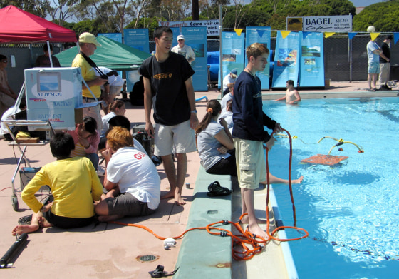 “Tetherman” Sam Minkoff, right, watches Milton Academy's underwater robot run through a warm-up drill as the rest of the team monitors the sub’s maneuvers on a pair of TV screens.