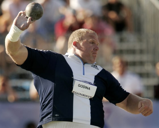 JOHN GODINA COMPETES IN QUALIFYING ROUND OF THE SHOT PUTT AT OLYMPIC TRIALS