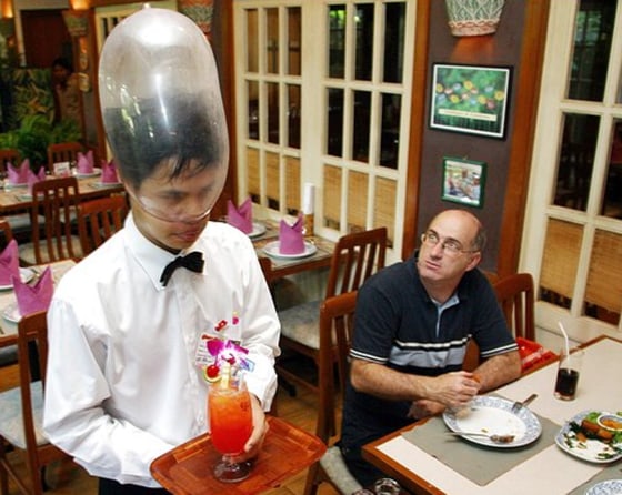 A Thai waiter wears a condom on his head at Bangkok's Cabbages and Condoms restaurant, founded by Mechai Viravaidya to promote safe sex education. Mechai said the government must take new steps against AIDS.