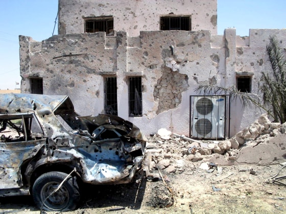 A vehicle used in a car bombing sits upended next to a police station Thursday in Haditha, Iraq. The blast killed 10 people in a second day of violence.