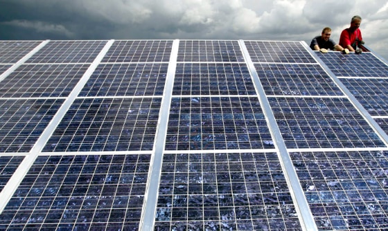 WORKERS SET UP PHOTOVOLTAIC ELEMENTS IN THE WORLD'S LARGEST SOLAR PARK PROJECT IN GOETTELBORN