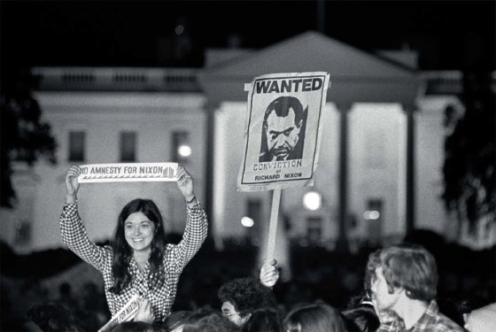 A crowd celebrating Nixon's resignationhold "Wanted Conviction of Richard Nixon" and "No Amnesty for Nixon" signs outside the gates of the White House.