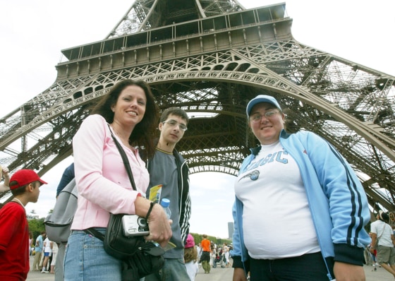 American tourists Nicole Nichols, left, from Florida; Alexin Hadji, center, and Georgina Nicolau, both from New England, stand Wednesday under the Eiffel Tower in Paris. 
