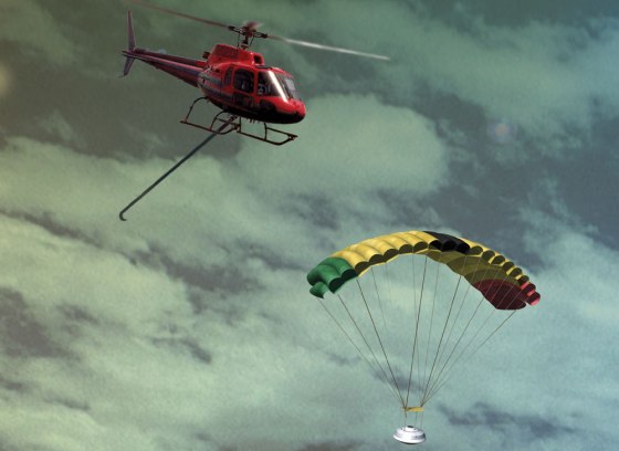 An artist's conception shows a helicopter extending its hook to snag the parachute attached to the Genesis sample return capsule.