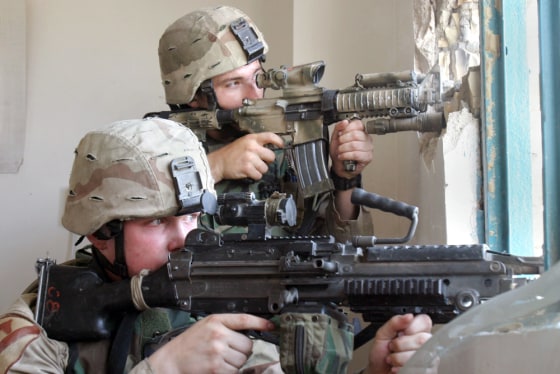 U.S. Army soldiers aim through the window of an abandoned hotel in Najaf, Iraq, on Monday.