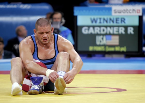Rulon Gardner, of United States, takes off his shoes to symbolize his retirement after defeating Sajad Barzi, of Iran, during Men's Greco-Roman&nbsp;wrestling bronze medal bout.