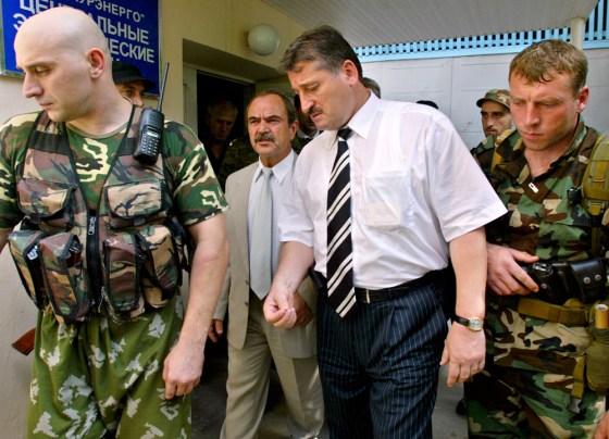 Surrounded by his bodyguards, Kremlin-favored candidate Alu Alkhanov leaves the central election commission in Grozny on Monday.