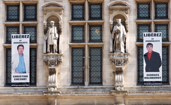 Portraits of kidnapped French journalists Christian Chesnot, left, and Georges Malbrunot are displayed on the main facade of the Paris City Hall on Wednesday.