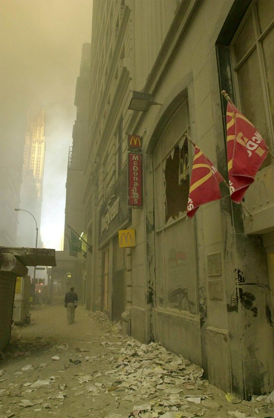 Several hours after the collapse of the World Trade Center in New York, the sidewalks are covered in a layer of thick dust and debris, and dense smoke fills the air.