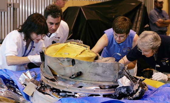 Scientists Amy Jurewicz, Don Sevilla, Judy Allton and Eileen Stansbery, left to right, examine and pick pieces of dirt from the Genesis capsule.