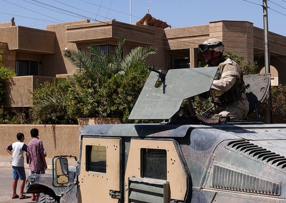 A U.S. soldier stands guard outside the house from which gunmen abducted the two Americans and a Briton.