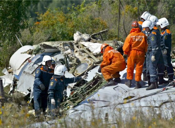 In this file photo, workers search the crash site of one of the planes downed in late August by Chechen bombers, who bribed their way onto the flights.