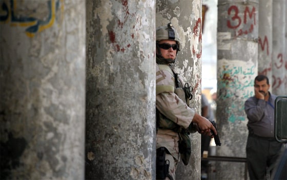 A US soldier secures the scene of a car bomb explosion in Baghdad