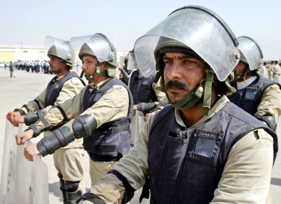 A group of Iraqi policemen in full riot gears stand in formation during anti riot training in Basra