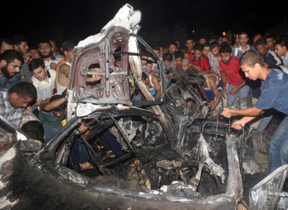 Palestinians gather around the wreckage of the car in which Adnan al-Ghoul was killed Thursday.