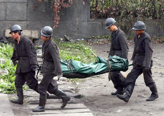 Rescuers carry a body of a miner from th