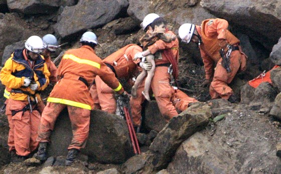 Rescuers remove Yuta Minagawa, 2, from a car buried in a landslide in Nagaoka on Wednesday.