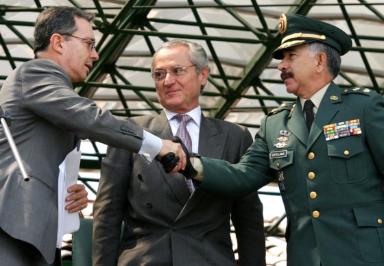 The new head of the Colombian army, Gen. Reinaldo Castellanos, right, shakes hands Thursday with Colombian President Alvaro Uribe during a military ceremony at a base in Bogota, Colombia. Defense Minister Jorge Alberto Uribe stands between them.