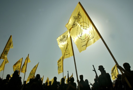 Palestinian militants of the Al-Aqsa Martyrs' Brigades hold flags during a rally in memory of late Palestinian President Yasser Arafat in Gaza strip