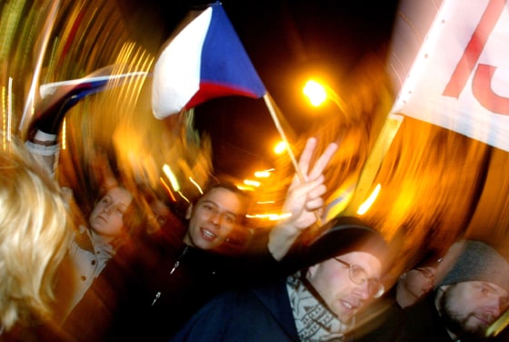 A marcher flashes a V-sign and waves a Czech flag at a Wednesday march commemorating the 15th anniversary of the 1989 Velvet Revolution in Prague, Czech Republic.
