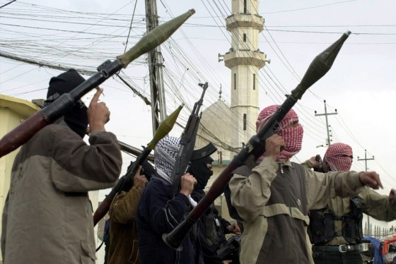 Insurgents gather on the street after two U.S. convoys were attacked in Mosul, Iraq, on Wednesday.