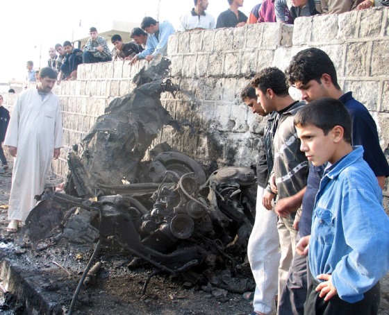 Iraqis look over the wreckage after a bomb attack in Mosul on Friday. One man was wounded in the suspected suicide car bomb attack.