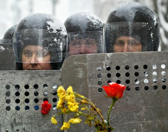 Riot police officers guard the Ukrainian presidential administration building in Kiev on Wednesday with flowers inserted into police shields by opposition leader Viktor Yushchenko's supporters.