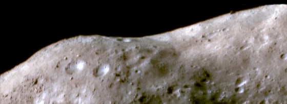 This false-color image of the asteroid Eros was taken by the NEAR Shoemaker spacecraft in October 2000 as it orbited 34 miles (54 kilometers) above the surface. In pale brown areas, the surface is thought to have been reddened and darkened by the solar wind and micrometeorite impacts. In white or blue areas, fresher materials are exposed from the subsurface on steep slopes.