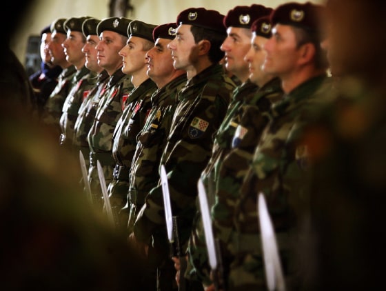 Soldiers of two Bosnias armies stand guard together during a ceremony in Sarajevo