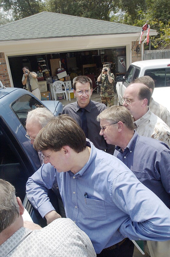 Garage door opener manufacturers peer at the electronics inside a car as a garage door in the background refuses to close in Valparaiso, Fla. The problems were caused by radio signals from nearby Eglin Air Force Base.