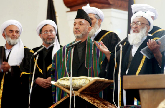Afghan President Hamid Karzai, center, stands next to Chief Justice Fazl Hadi Shinwari, right, as he takes the oath of office during a ceremony at the Presidential Palace in Kabul, on Tuesday.