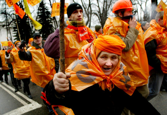 An elderly supporter of Ukrainian opposition leader Viktor Yushchenko raises her walking stick as she and fellow protesters march in front of the parliament building in Kiev on Tuesday.