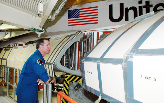 A crew member for the next shuttle mission, Stephen Robinson, looks inside the wing of the shuttle Discovery, which is in the Orbiter Processing Facility at NASA's Kennedy Space Center for launch processing. Discovery is scheduled for launch no earlier than May 12.