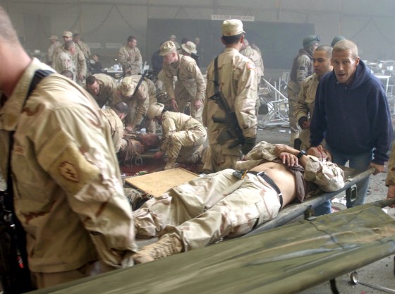 Workers and U.S. soldiers tend to the wounded Tuesday after an attack on a crowded dining hall at a U.S. base in Mosul, Iraq.
