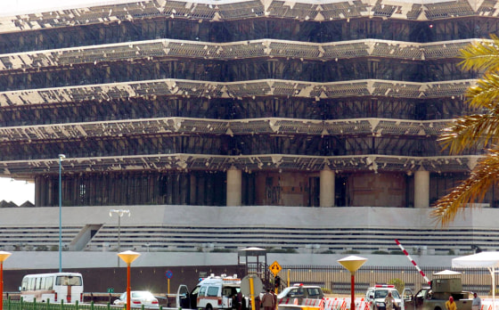 Saudi rescue workers are seen Thursday at the gate of Saudi Arabia's interior ministry, which was damaged by an explosion in Riyadh late on Wednesday.