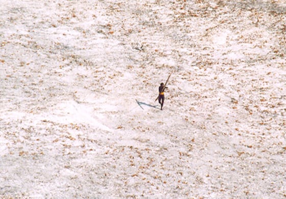 A Sentinel tribal man aims with his bow and arrow at an Indian Coast Guard helicopter flying over the Andaman and Nicobar archipelago, India