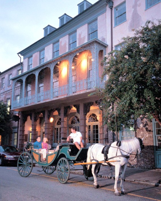 A couple takes a carriage ride in front of Historic Dock Street Theater, in Charleston, S.C.