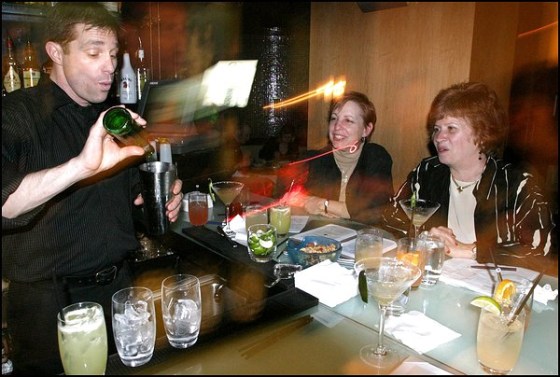 Palette bartender John Roberts instructs Rene Lawson, center, and Kaki Power on how to make an Alamo Splash, a classic Texas cocktail.