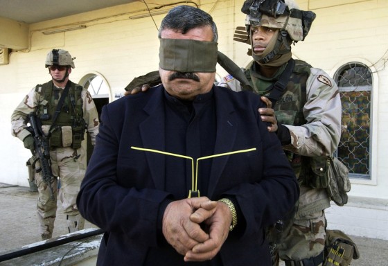 An Iraqi man is detained by U.S. soldiers during a weapons raid at a gas station in Mosul on Tuesday.