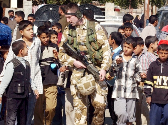 A British soldier walks among Iraqi children in the Hyyaniah area of Basra on Thursday.