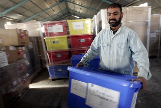 An Iraqi election worker carries a ballot box after their arrival at a warehouse in Hilla, 75 miles south of Baghdad, on Friday.